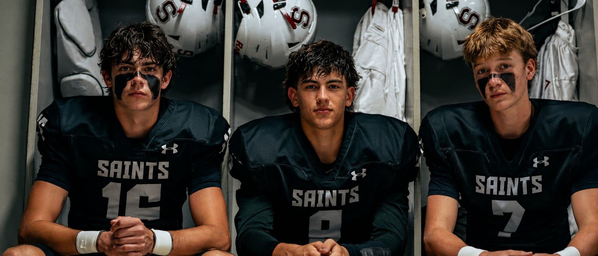 Saints athletes on the sideline under the lights